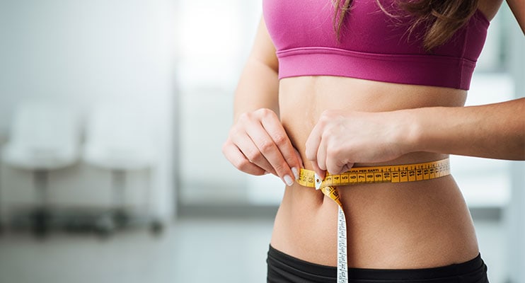 Woman In Pink Tanktop Measuring Her Weight Loss