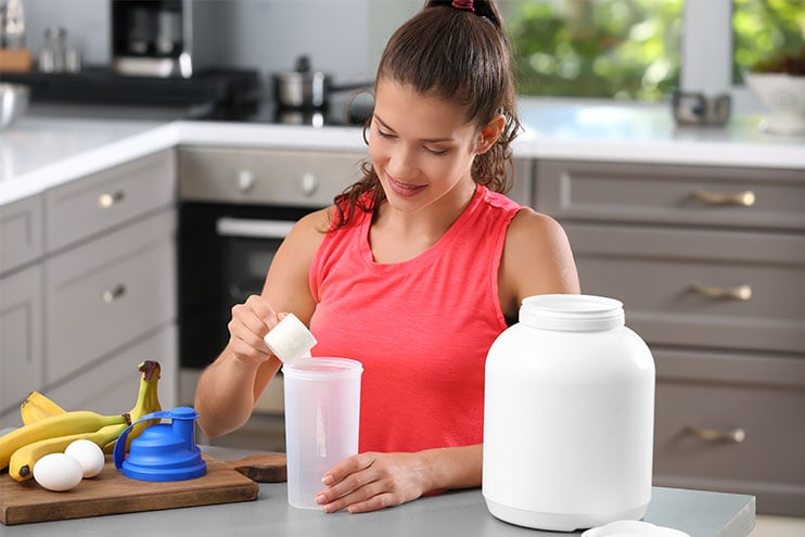 Young Woman Making A Protein Shake In The Kitchen