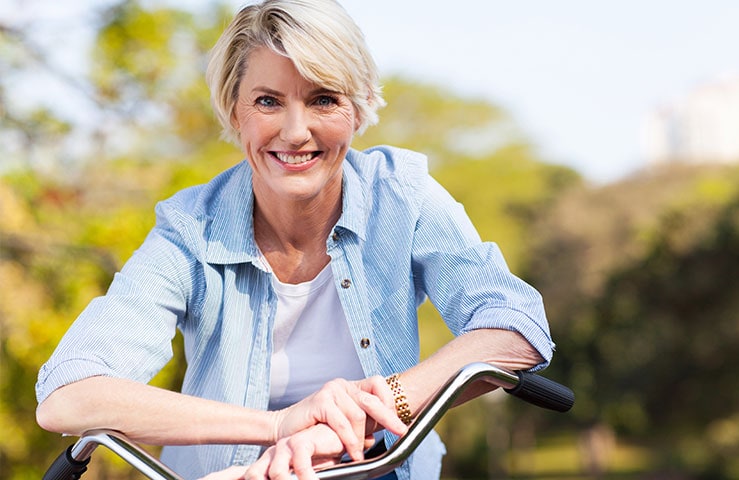 Older Woman Leaning Over On Her Bike